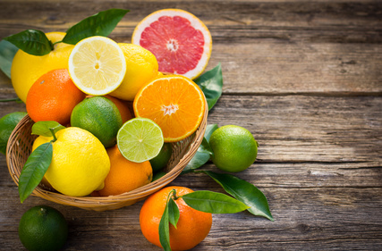 Fresh and juicy citrus fruits in the basket on the rustic table