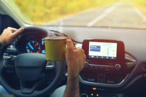 Man with coffee cup driving