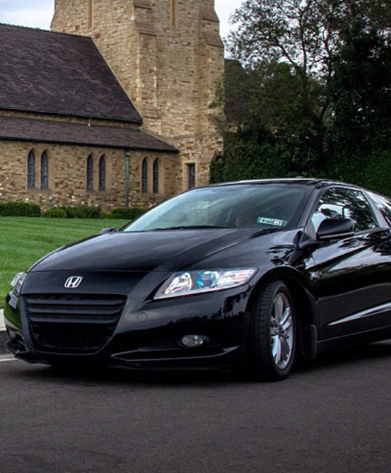 A black Honda Accord parked in front of a church with concierge service
