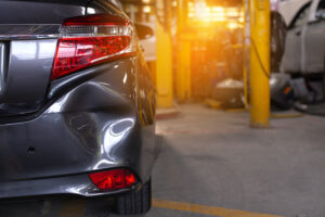 Close up of the rear bumper dent of a grey car in preparation of repair work,Make the surface of the car smooth ,preparing for painting at station service.