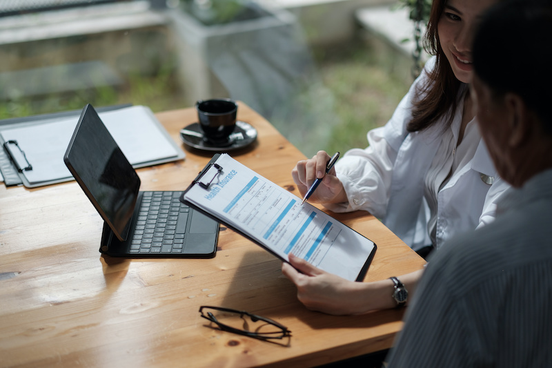 Female health insurance broker presenting his insurance benefits to businessman fill out insurance policy. To prevent future incidents