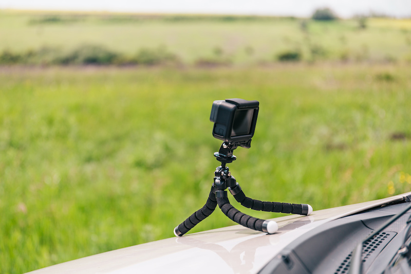 Action camera on flexible tripod on the hood of car recording  time-lapse, copy space