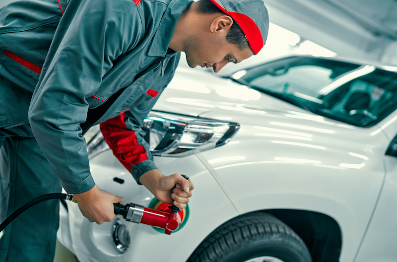 Auto mechanic buffing car autobody. Car repair and maintenance.