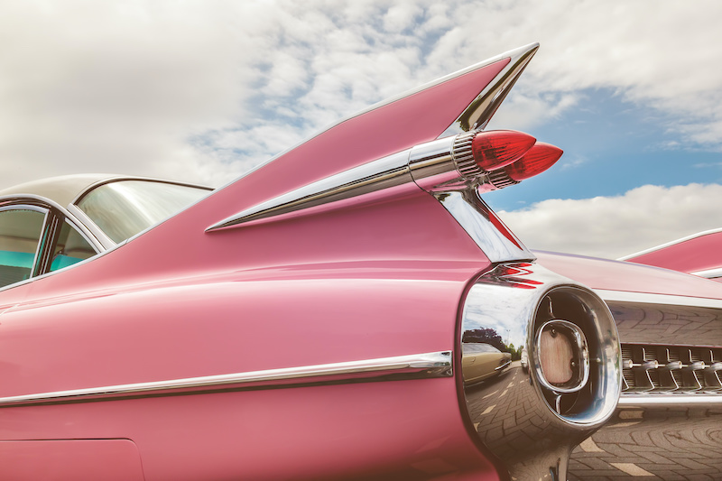 Retro styled image of the rear end of a pink classic car