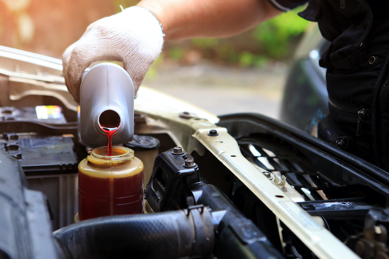 A hand filling car power steering fluid