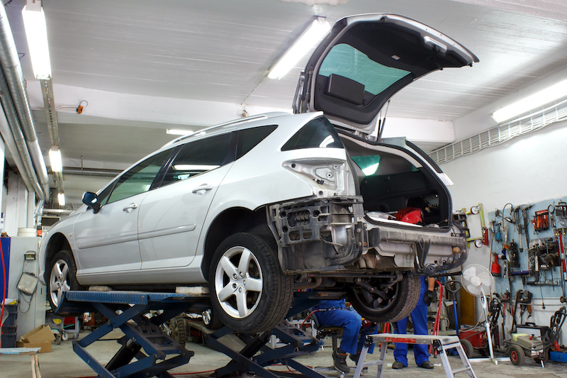 *** Local Caption *** Car is lifted in car body repair service