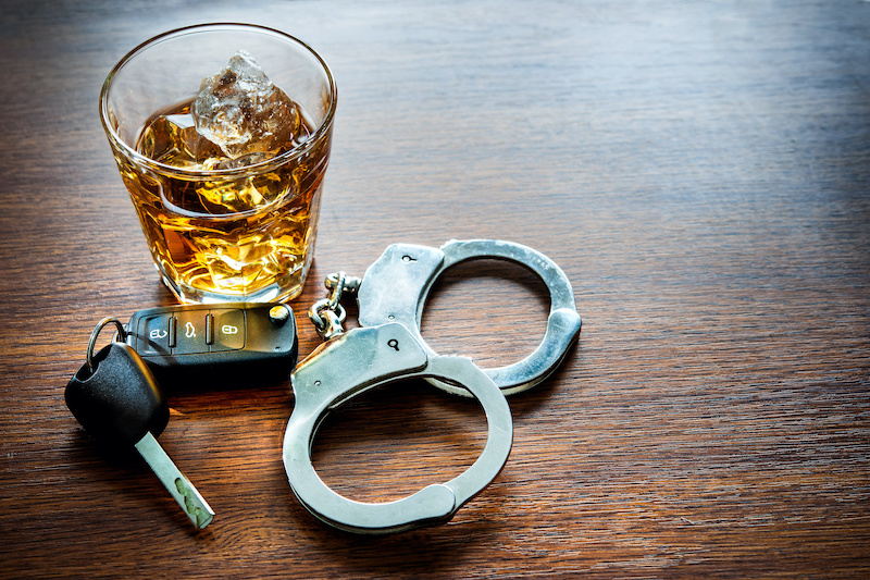 Whiskey with car keys and handcuffs concept for drinking and driving