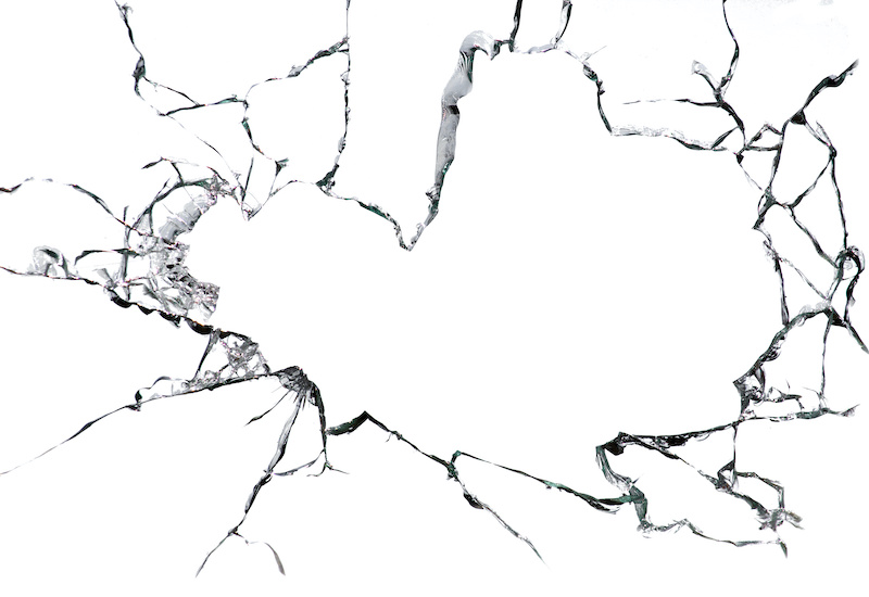 Cracked broken glass on a white background. Damaged window texture.