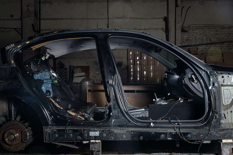 Disassembled car interior without doors. armchairs and other panels in a car workshop.Work at the auto service