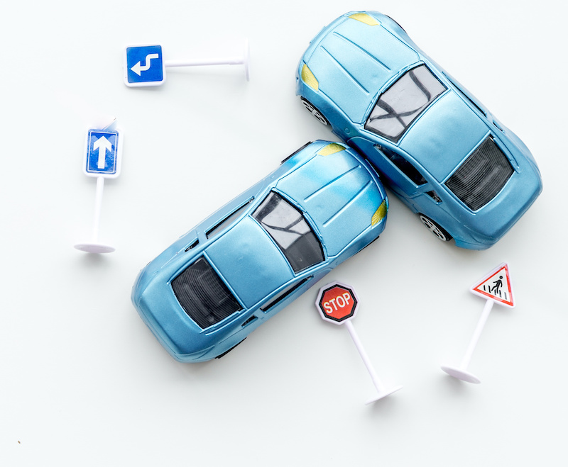 Car insurance concept with car toys on white desk background top view copyspace