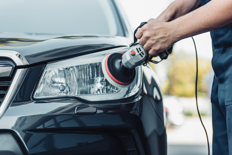 headlight cleaning cropped view of car cleaner polishing headlamp with polish machine