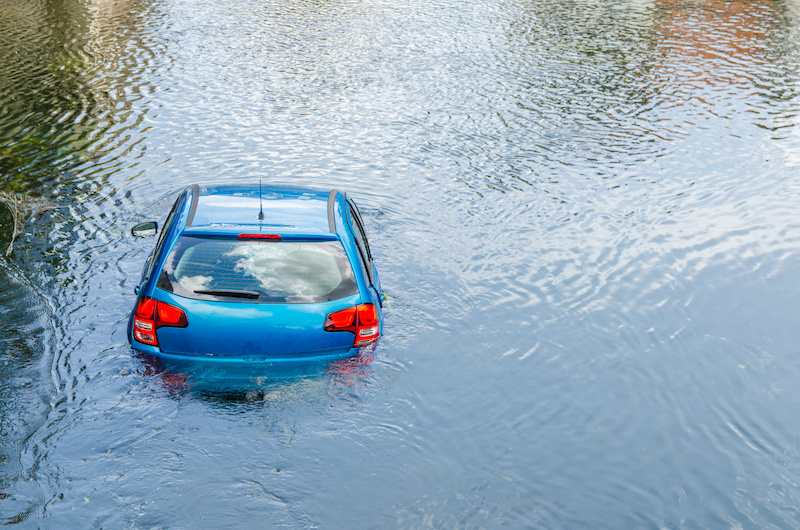 Blue car drown in water canal. Extreme accident vehicle sink in river pound lake, traffic incident