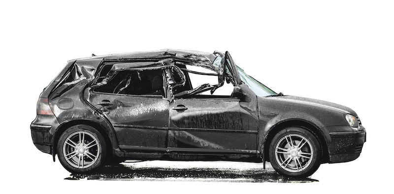 totally loss crashed black Volkswagen Golf 4 after aside impact stands on rainy road, on white