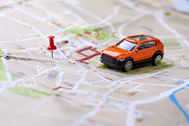 travel concept - small toy car on the map road trip