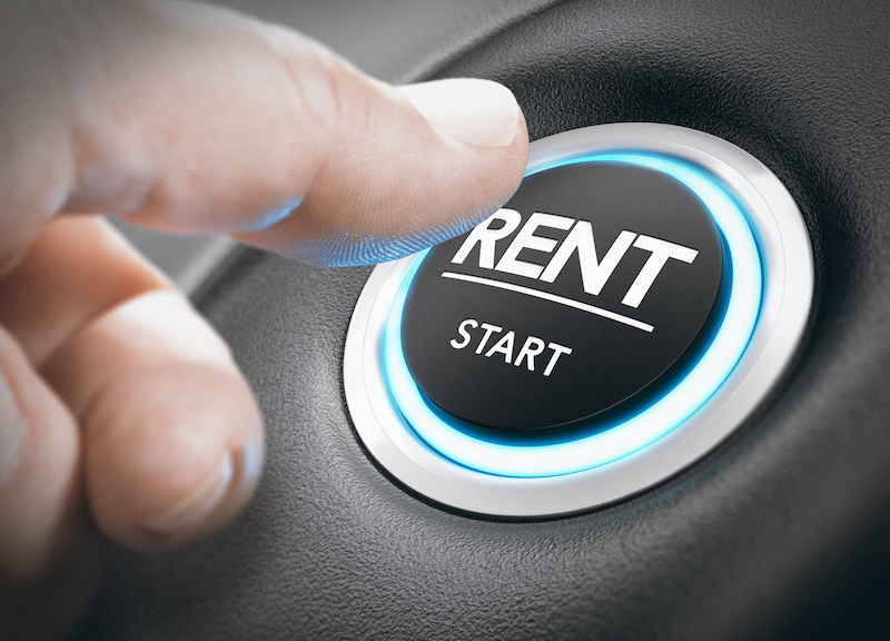 Man pushing a start button with the word rent. concept of car or vehicle rental. Composite image between a hand photography and a 3D background.