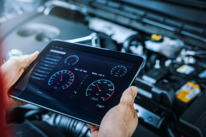 car engine diagnostics. service mechanic using digital tablet to inspect vehicle condition