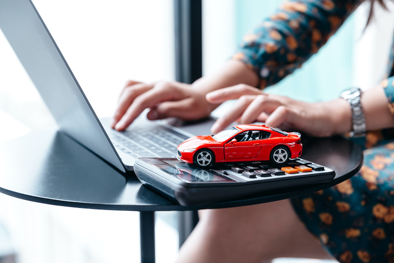 car finance and insurance concept. Young woman selling or buying car online.