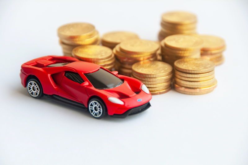 Kuala Lumpur, Malaysia - September 2022 : Miniature toy car of Ford GT with gold coin background. Copy space.