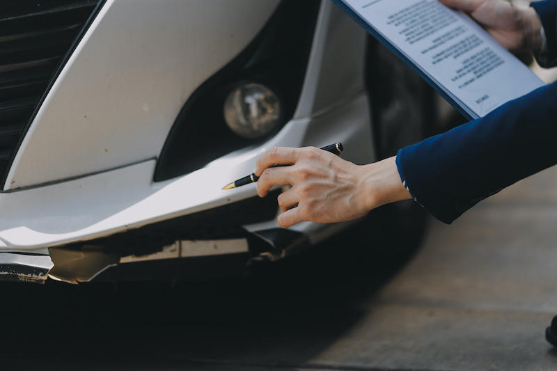 A young businesswoman is navigating car insurance options at her desk, considering premiums, deductibles, and coverage while understanding policies and managing claims efficiently.