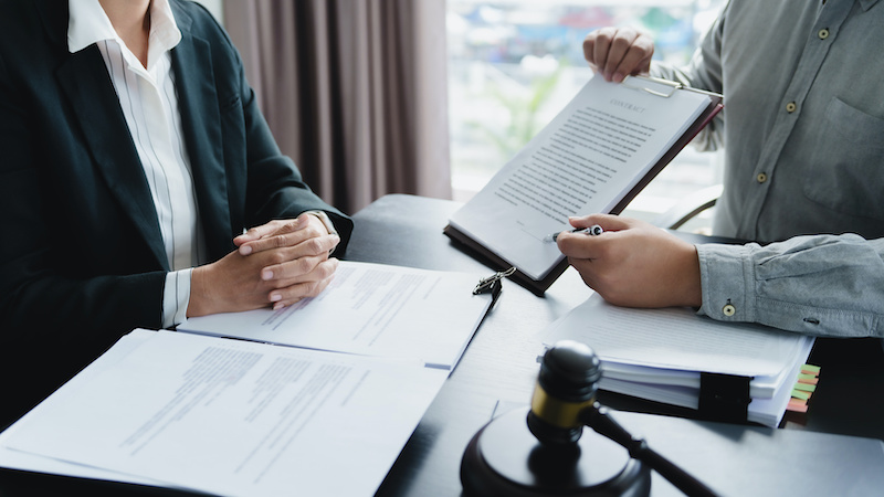 Labor law concept. Lawyer signing legal document with Judges gavel.