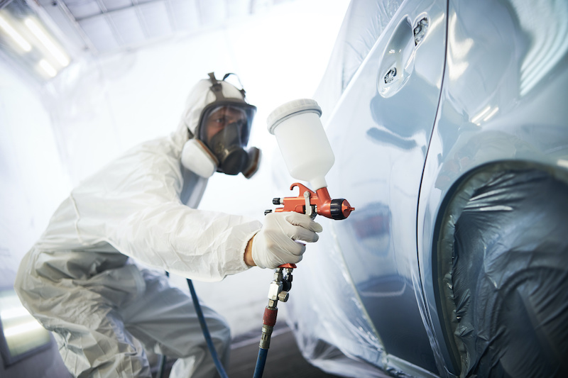 auto painting worker. car in a paint chamber during repair work