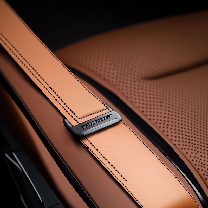 Close-up of an elegant car seat with leather upholstery and a stylish seatbelt clasp.