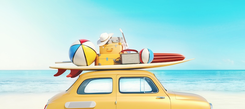 Small retro car with baggage, luggage and beach equipment on the roof, fully packed, ready for summer vacation, concept of a road trip with family and friends, dream destination, very vivid colors with dominant blue sky and ocean and bright yellow car.