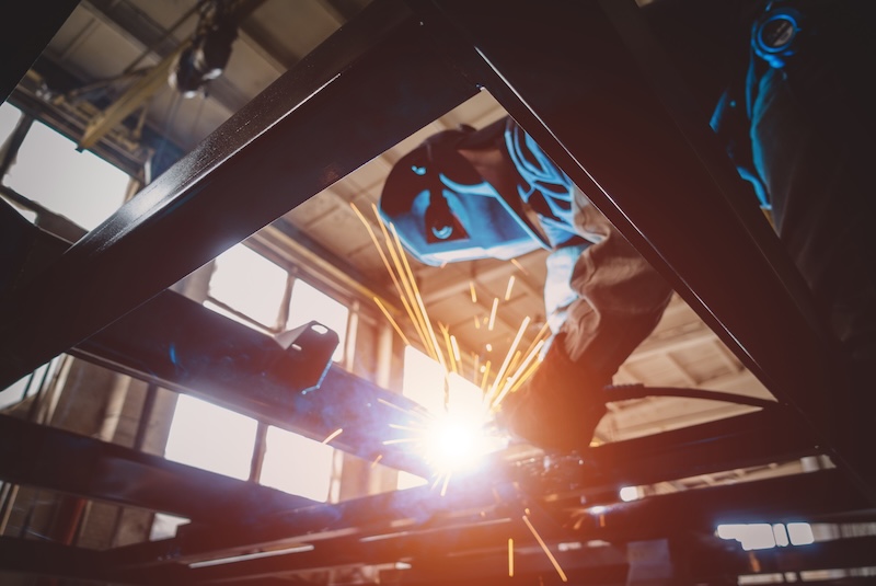 Welder welds metal frame straightening of car