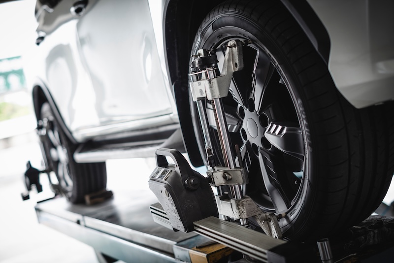 Car wheel alignment services in garage service shop.
