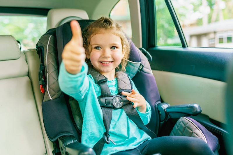 A Small child sitting in a car seat in the car child passenger safety