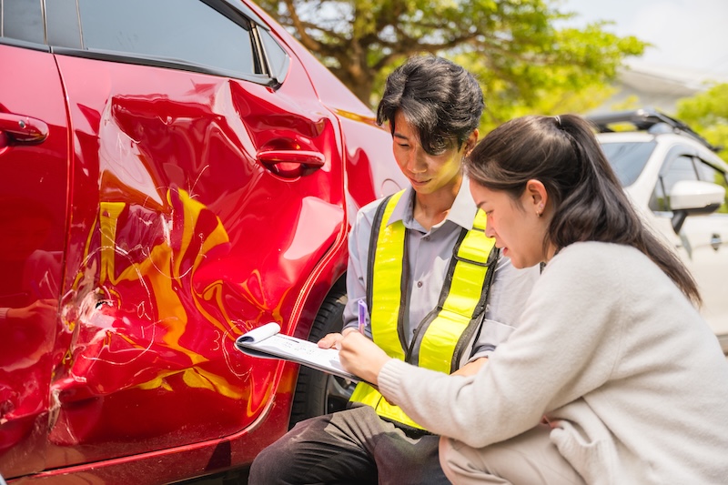 Car accident crash, Cars insurance protection, Claim collision, Auto emergency. A man and a woman are examining a damaged car that has been involved in an accident.