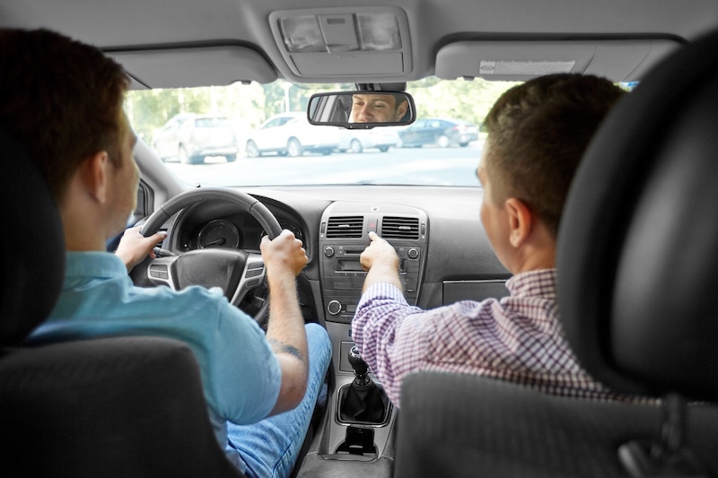 driver courses and people concept - car driving school instructor teaching young man to drive