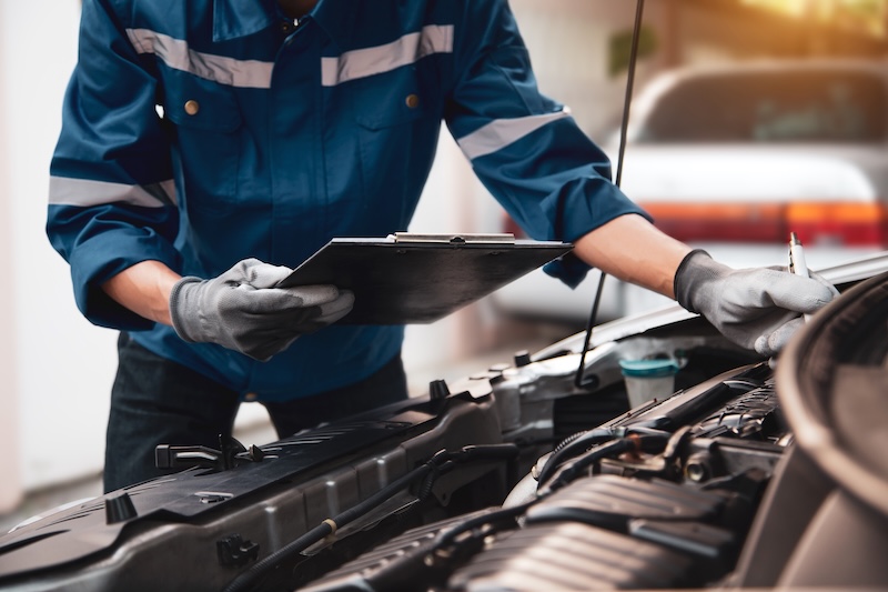 Car care maintenance and servicing, Hand technician auto mechanic checking inspection list after fix or repairing change spare part car engine problem and car insurance service support assistance.