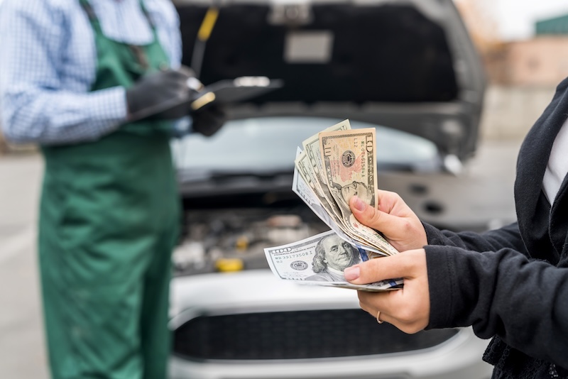 Female hands with dollars, payment for car service