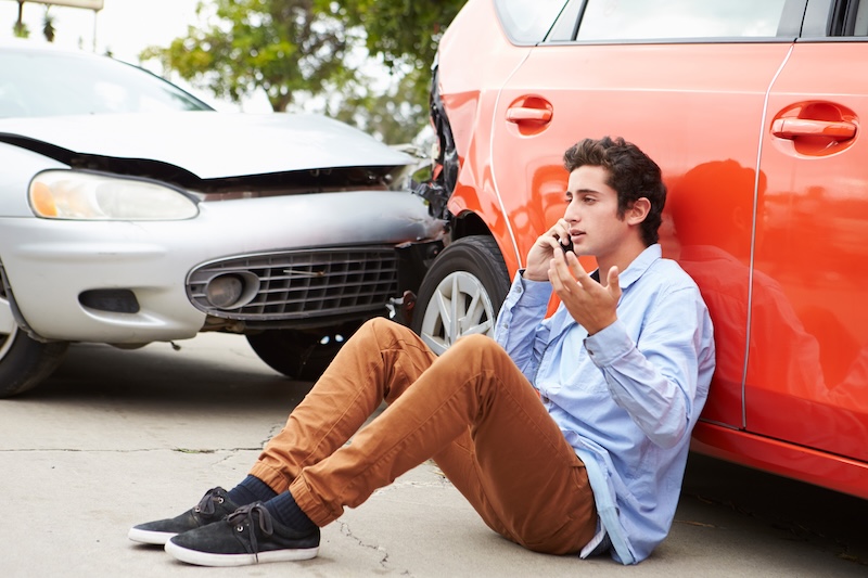 Teenage Driver Making Phone Call After Traffic Accident