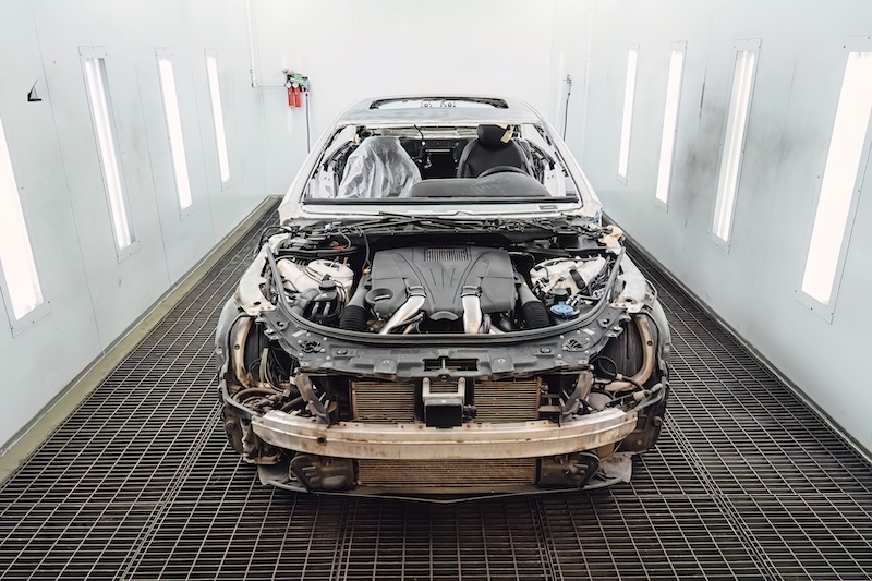 Car body shell completely disassembled after an accident in an auto service garage for major body repair and structural frame restoration work. Industrial shot for advertising and service promotion