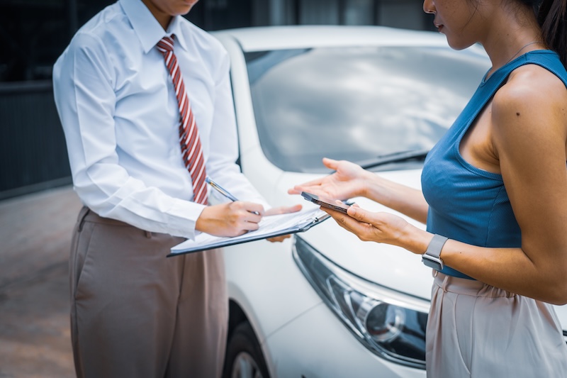A young businesswoman is navigating car insurance options at her desk, considering premiums, deductibles, and coverage while understanding policies and managing claims efficiently.