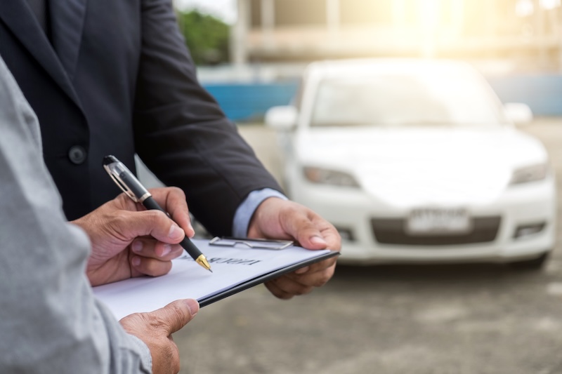 Insurance Agent examine Damaged Car and customer filing signature on Report Claim Form process after accident, Traffic Accident and insurance concept.