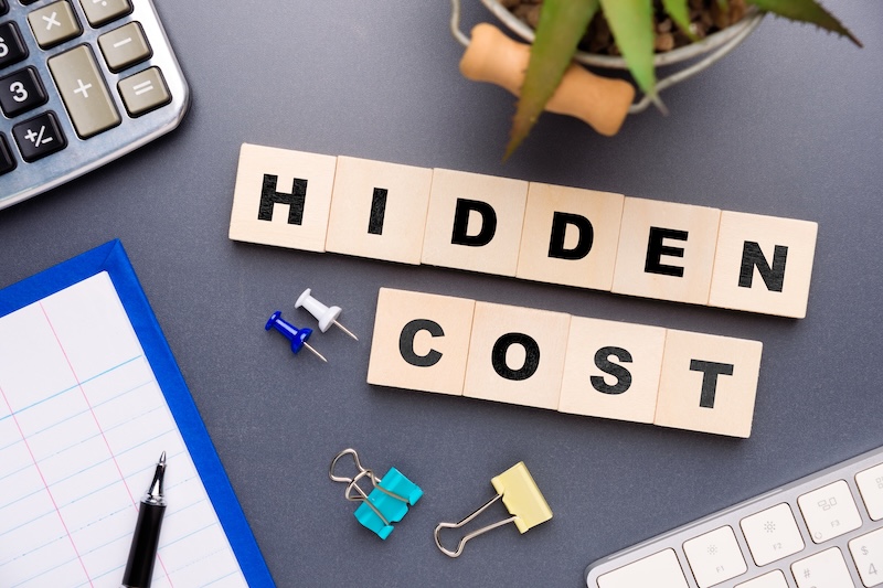 Wooden blocks spelling hidden cost, symbolizing unseen expenses overlooked, indirect financial impacts affecting business decisions, planning, and long term performance
