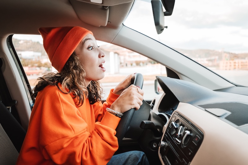 A novice girl parks a car during an exam or a driving lesson. A small accident and a bumper scratch concept