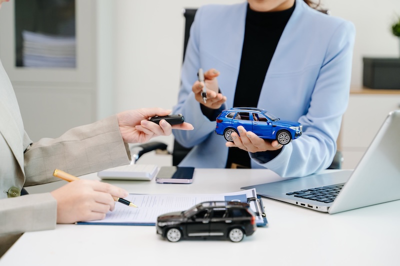 Car insurance consultation using smartphone and documents. Advisor and customer reviewing digital insurance service, auto policy, finance, technology and modern business solution.
