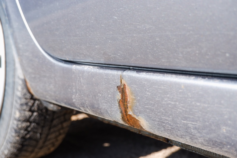 Corrosion, rust on the car body. car with Rust and Corrosion and paint bitumen. The concept of harm from reagents for the environment. Selective focus