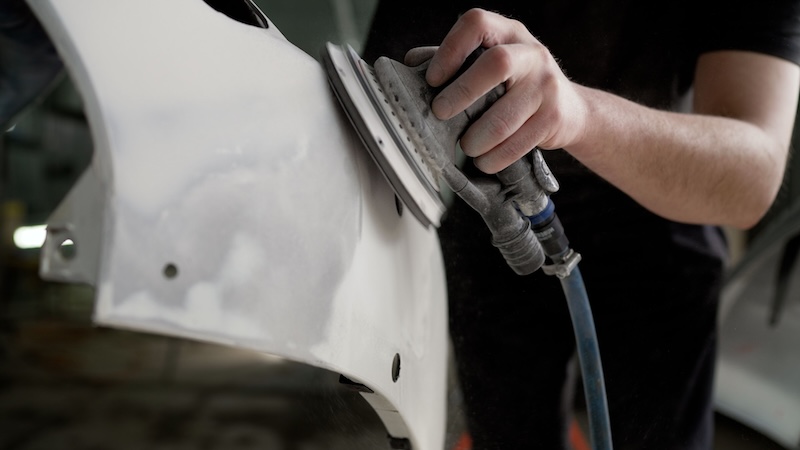 Sanding a car bumper before painting. A worker professionally cleans the surface of a car bumper with a grinding machine in a car service garage before painting, close-up. SSUCv3H4sIAAAAAAAACnxTwY6bMBC9V+o/RD5vJIODCfsPlXrobbWHwZ4kVoyNjEm1WuXfO0BMTLXtjXljv3l+8/j8/m23Yy0MRrHX3edUUW2sHYcYIBrvCOYvDzyg0xhy5BaE5DkAJq9Qm+iDAZuDLUR1cdAhgW60doLvc5MNEeI44JBpKUoRTlQX6Xrvna4IEAnQAaEbopkJV7Tzk3q02KGLE2GRzVEQ8UzCNpOSC29LvUuNuUk3qMV+IUn31p8/2EvWHcZ26v4wg0JrwaEfB5b6y8x/EP5E31v8kgzdk2L5eF9dPqNTH0/tEx+5EM0NOwhXjPkzJhNXpvfl456ZEcgkWEx/Wyaw6++IoZvNeRyCURufmXXzCux0QGRMYHoIsLnXB6OMO2eIj5c5Q4lJ+dHFMD2GFXWVnGDW+x5asuZ1F8OICb7AMNAFTfCJBGC+VMqs77JJzsf5VWwhZZq2Po8Roiq4qMqmrmXDi2PB8vhdDPHMgpLEsbceNOqN4Wsway6rqjmKlNAso2uvfPY2cV0PpNx+mdz6cUg+lpfMoKR0Jsa/hG2GS15Xx/8Nl7wp5h1uQ0EWqKvR+f+ReFkpBZfNoZTrsja0TPDqIGUpxJy6B6GZRNIKRKP4Qe8L3sr9oYXTvi2l2telLkvgBRAv3br/AQAA//8DAEotJGiYBAAA